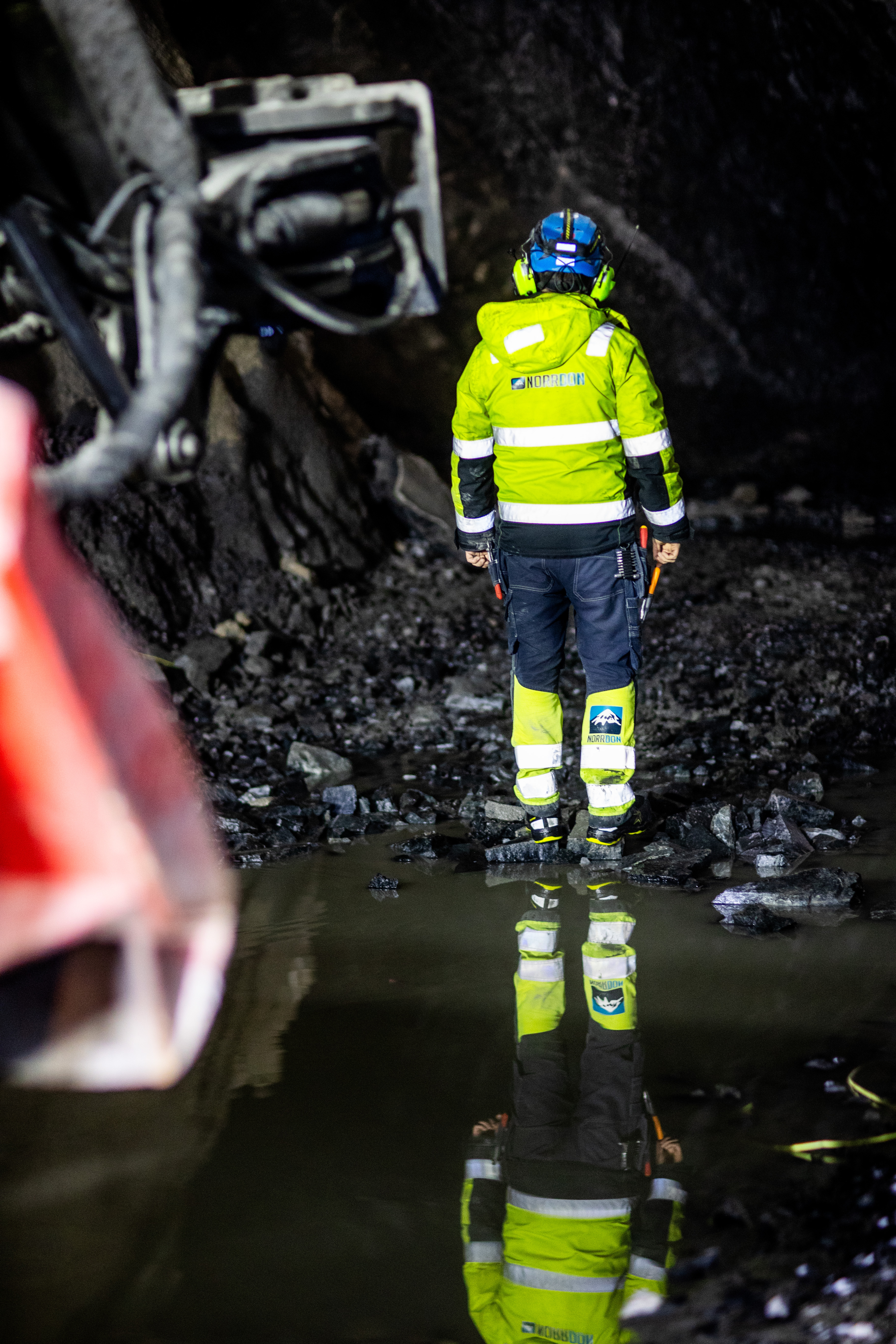 Norr-Don worker standing in an underground mine with water reflecting their high-visibility workwear